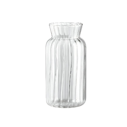 ribbed glass flower vase with water and single rose stem