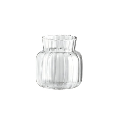 clear glass vases with rose and small white flowers on wooden tray