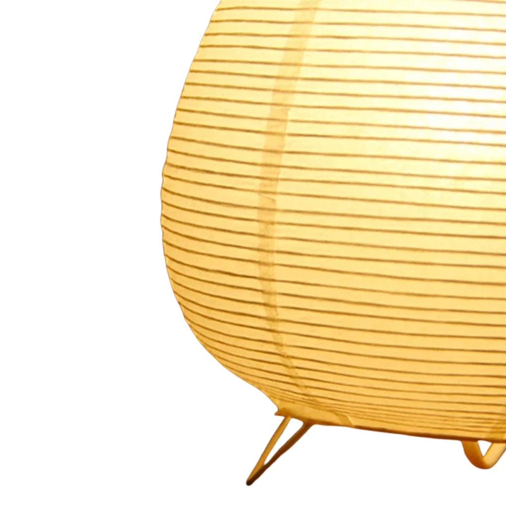 Bedside table lamp with round rice paper shade for bedroom decor.
Small paper nightstand lamp with soft warm light on tabletop.