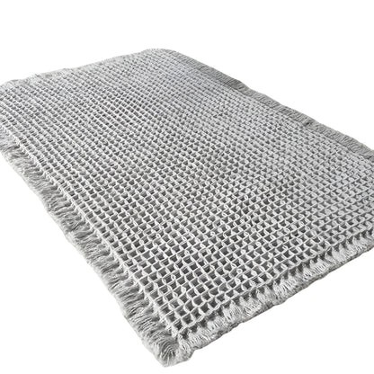 beige Bath Rugs & Mats with woven texture placed beside a shower
gray bathroom rug with raised waffle pattern and fringed edges
microfiber bath mat on bathroom floor with foot stepping on it
textured bathroom mats shown in beige and gray color options