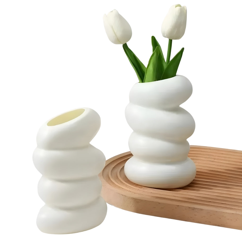 white flower vase with spiral stacked shape and angled opening
modern white bud vase for shelf or tabletop decor
spiral flower vase in white resin style for home decoration
small white vase with curved layered design on a plain background