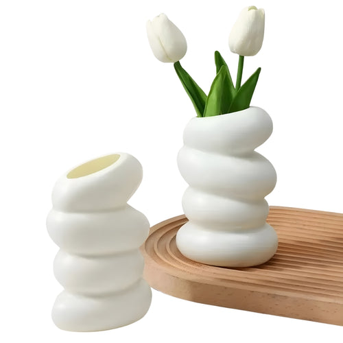 white flower vase with spiral stacked shape and angled opening
modern white bud vase for shelf or tabletop decor
spiral flower vase in white resin style for home decoration
small white vase with curved layered design on a plain background