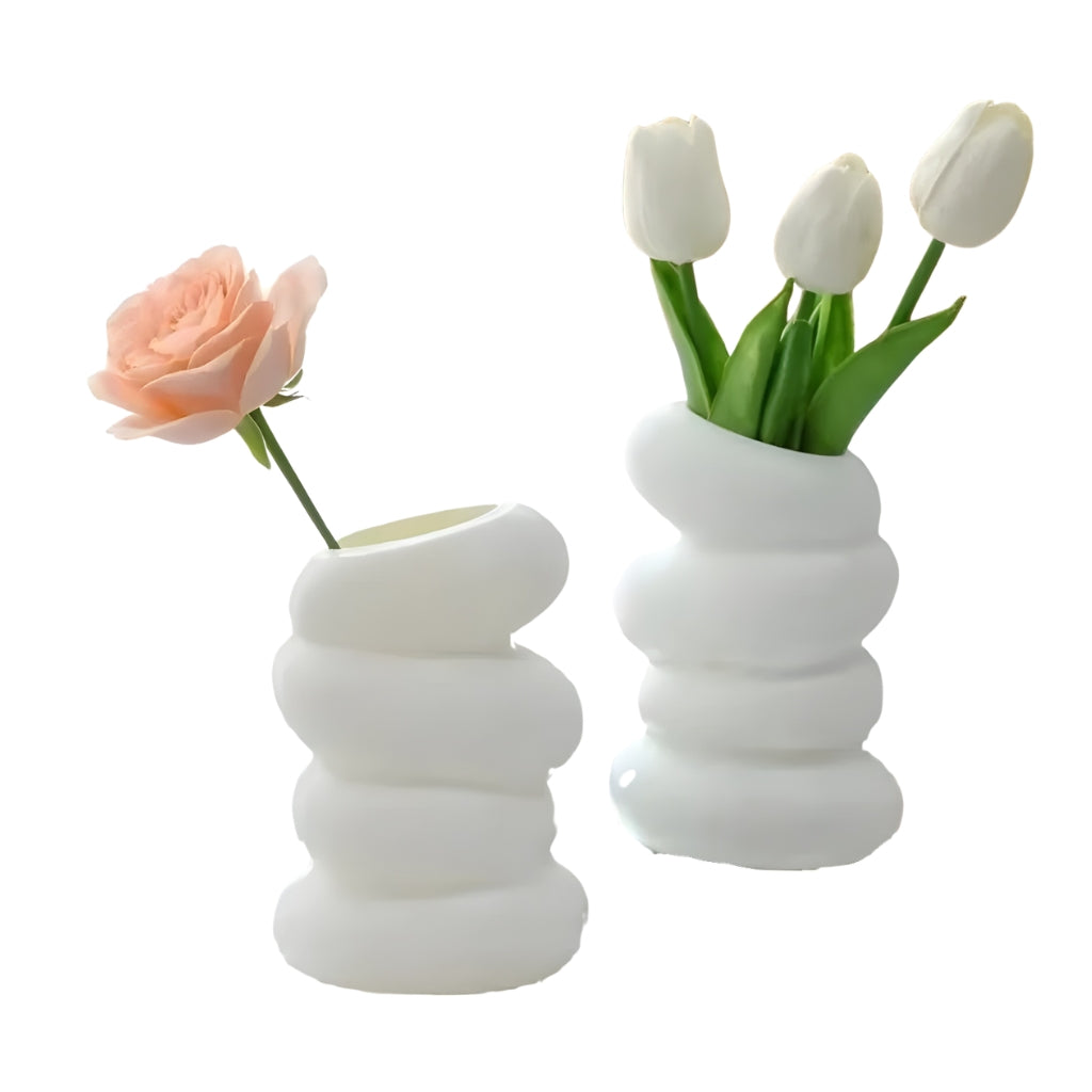 white flower vase with spiral stacked shape and angled opening
modern white bud vase for shelf or tabletop decor
spiral flower vase in white resin style for home decoration
small white vase with curved layered design on a plain background